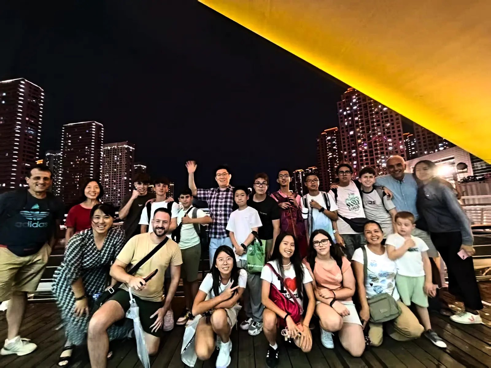 An evening group photo on a city terrace with the skyline behind