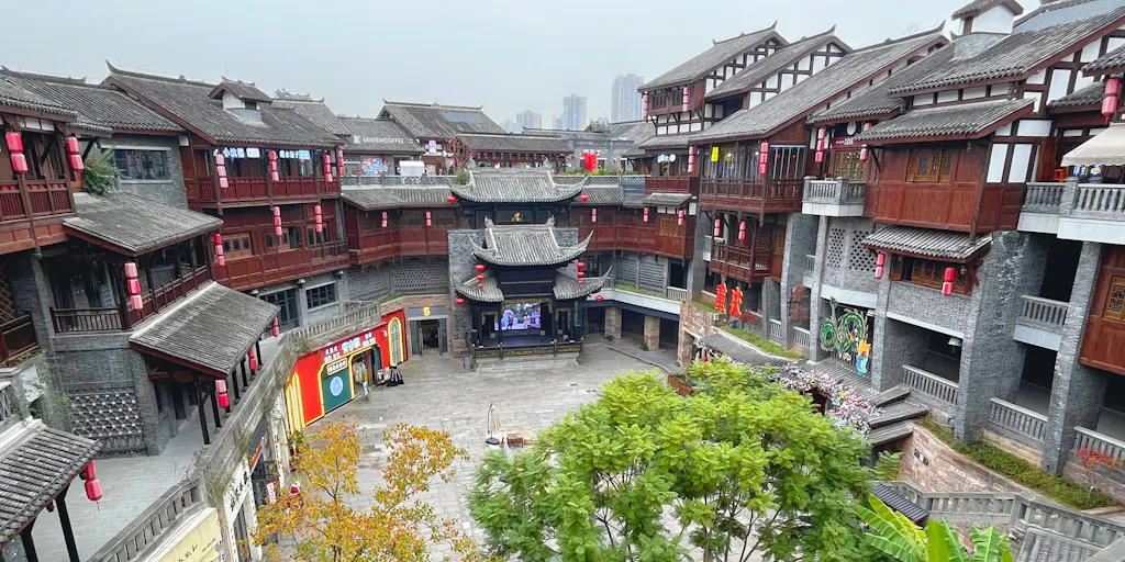 Grey-tiled courtyard buildings of a traditional Beijing village quarter seen from above — stand-in for a photo of the Gaobeidian campus and village