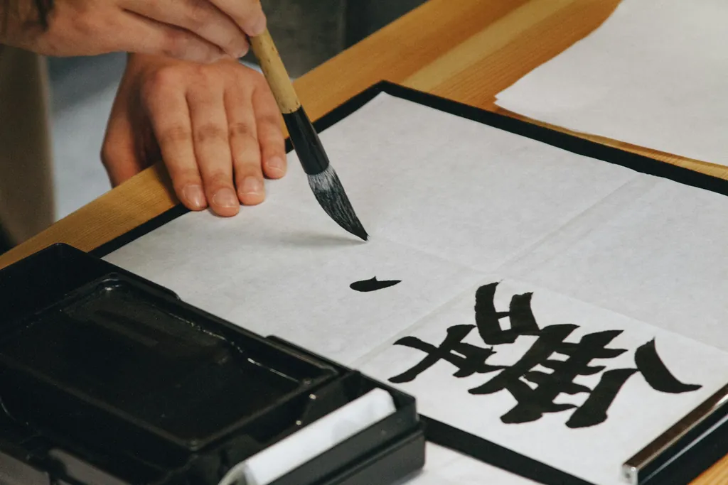 A hand writing a large Chinese character with an ink brush — placeholder for a close-up of a student's own character practice